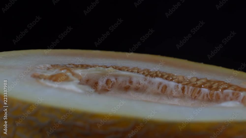 Yellow melon on a black background, close up. Rotates half yellow melon, macro Yellow melon on a black background, close up. Rotates half yellow melon, macro
