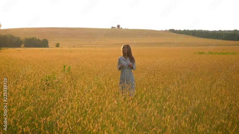 Gorgeous asian woman standing in yellow grass on what field and enjoying nature Gorgeous asian woman standing in yellow grass on what field and enjoying nature