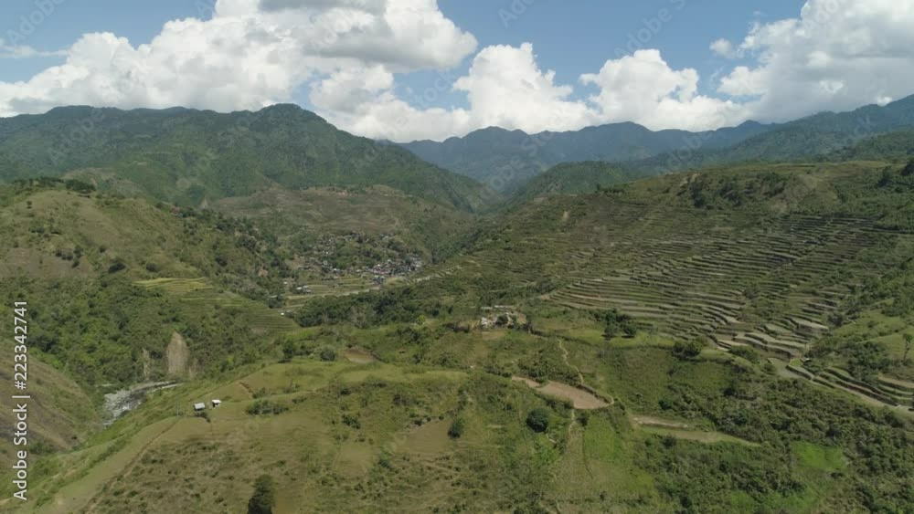 Aerial view of rice terraces and agricultural land on the slopes of the mountains. Village of farmers near rice fields in mountain valley. Mountains covered forest, trees. Cordillera region. Luzon Aerial view of rice terraces and agricultural land on the slopes of the mountains. Village of farmers near rice fields in mountain valley. Mountains covered forest, trees. Cordillera region. Luzon
