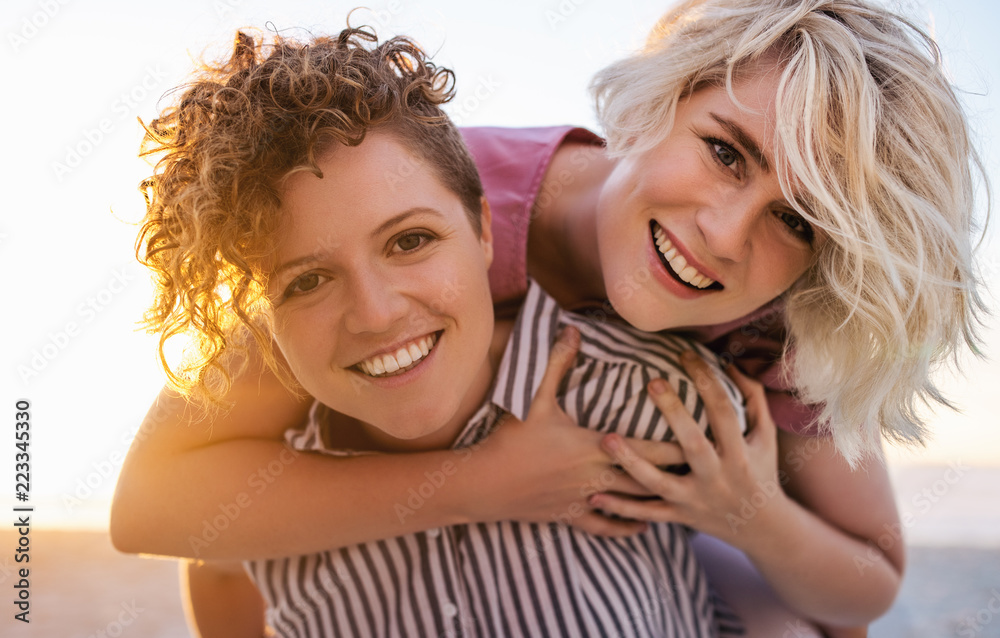 Carefree young lesbian having fun together at the beach Carefree young lesbian having fun together at the beach