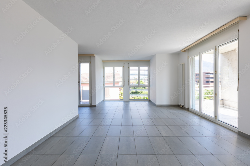 Empty room with tiles and large, bright windows Empty room with tiles and large, bright windows