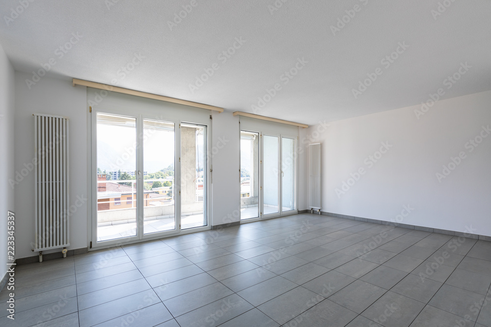 Obraz premium Empty room with tiles and large, bright windows