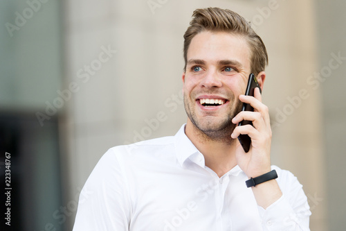 Happy to hear you. Man well groomed speak mobile phone urban background. Businessman cheerful call friend. Friendly mobile conversation. Guy handsome attractive office worker speak mobile phone