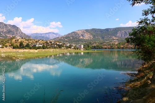 landscape with a lake and a village in the mountains on a sunny day