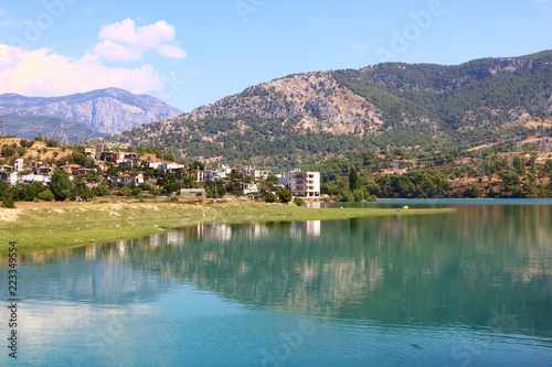 landscape with a lake and a village in the mountains on a sunny day