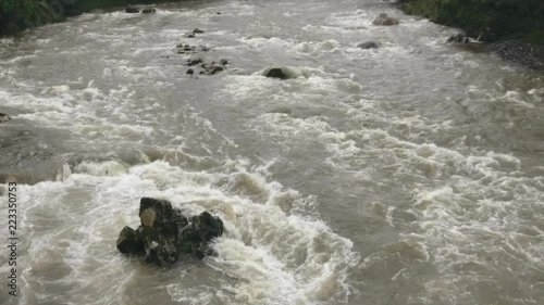 Aerial slow motion shot of a river in flood. The Rio Abanico on the Amazonian slopes of the Andes, Morona Santiago province, Ecuador, after heavy rain. photo