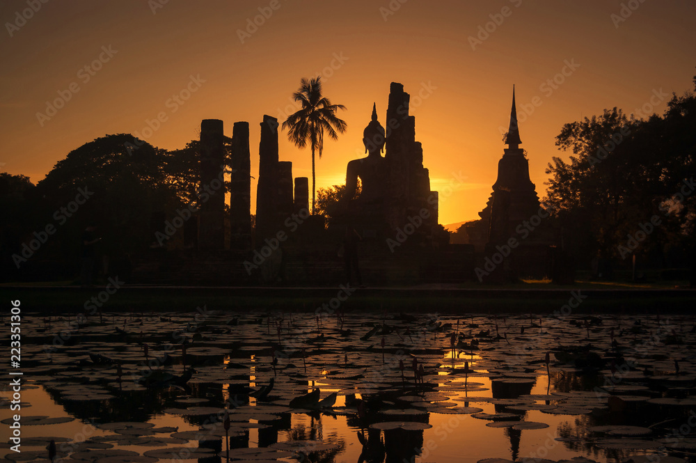 Silhouette at of Buddha and pagoda on sunset time at Sukhothai History park,Thailand. Thailand tourism concept, Asia traveling concept.
