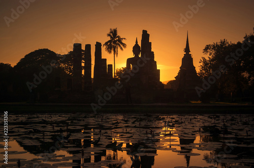 Silhouette at of Buddha and pagoda on sunset time at Sukhothai History park,Thailand. Thailand tourism concept, Asia traveling concept. © runrun2