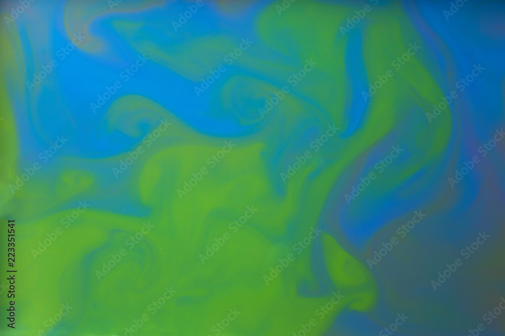 Colored liquids mixed together in fluid creating colorful abstract background