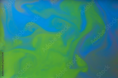 Colored liquids mixed together in fluid creating colorful abstract background