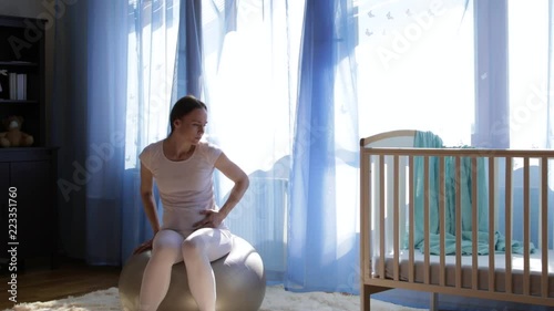 Future young mother is sitting on the fit ball.