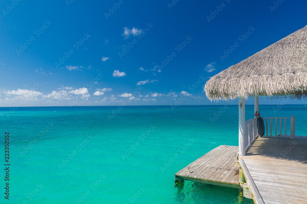 Beautiful beach with water bungalows and long jetty at Maldives. Summer travel holiday concept.