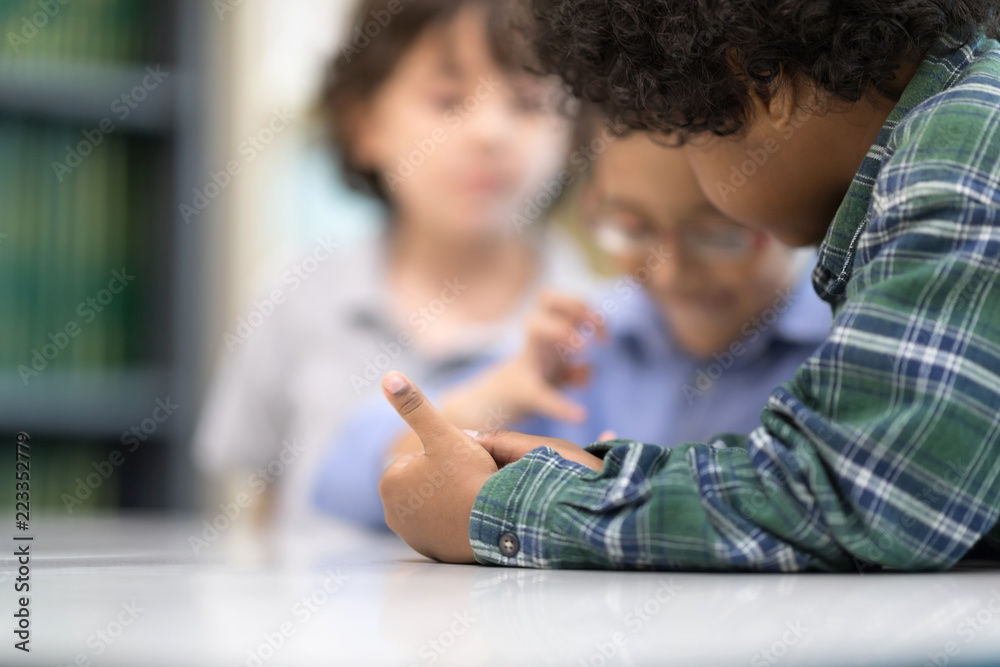Selective focus at left hand little boys watching Phone. Happy Children Learning Class in Library. Development of Human Resources in Education Concept. Setup studio shooting. Selective focus at left hand little boys watching Phone. Happy Children Learning Class in Library. Development of Human Resources in Education Concept. Setup studio shooting.