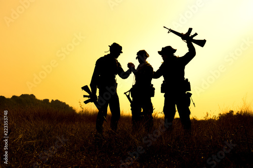 Military soldier holding weapons overhead after get victory.