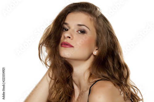 Portrait of young beautiful woman with long curly hair on white background