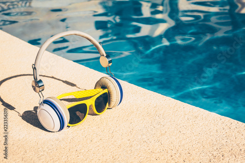 Sunglasses and headphones by the pool - fashion accessories