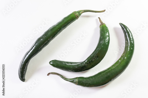 Top angled view of three green chilaca peppers isolated on white, horizontal aspect photo
