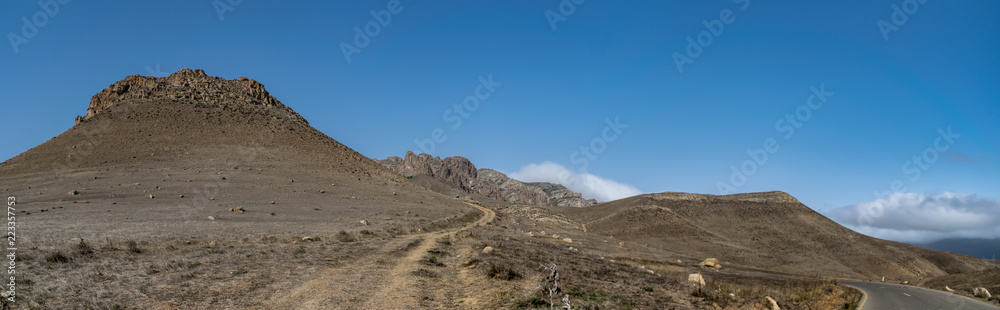 Trekking path in the mountains with a view of high rocks and blue sky. Talysh Mountains. Azerbaijan, Yardymli. mountainous road