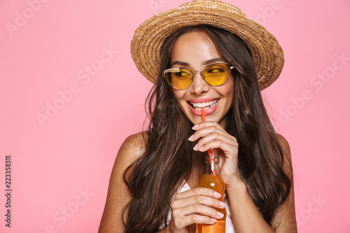 Valokuvatapetti Photo closeup of european woman 20s wearing sunglasses and straw hat drinking ju