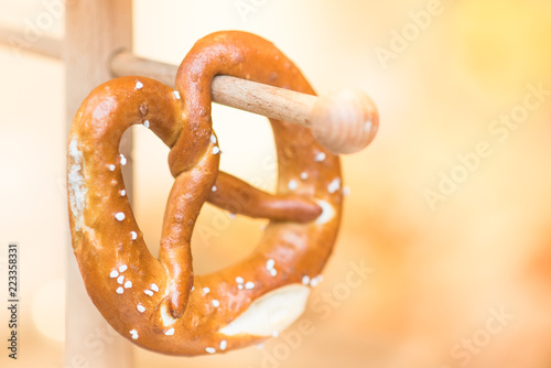 Fresh Pretzel hanging background. Twisted-knot shaped crusty white bread roll traditionally served with beer on famous German Oktoberfest in Munich, is popular in many European countries and USA