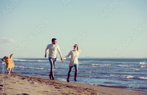 couple with dog having fun on beach on autmun day © .shock