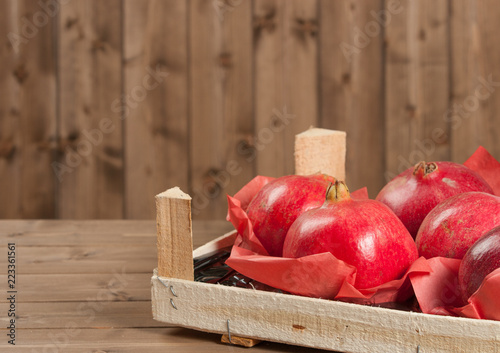 Ripe Pomegranate Fruits In Wooden Box.