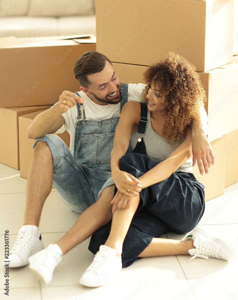Newlyweds talking while sitting near cardboard boxes Newlyweds talking while sitting near cardboard boxes