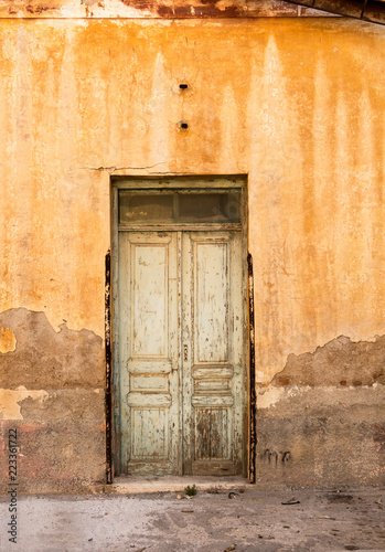 Weathered door, on rusty painted wall.
