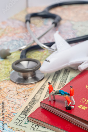 Miniature figures of paramedic personnel attending sick person in a foreign country concept.