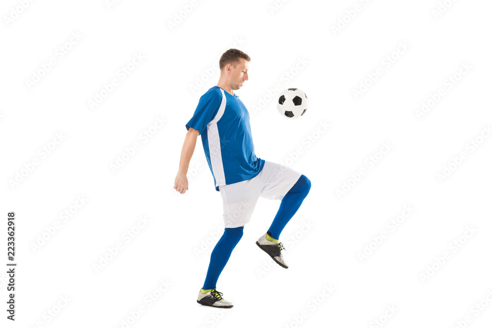 side view of young soccer player training with ball isolated on white