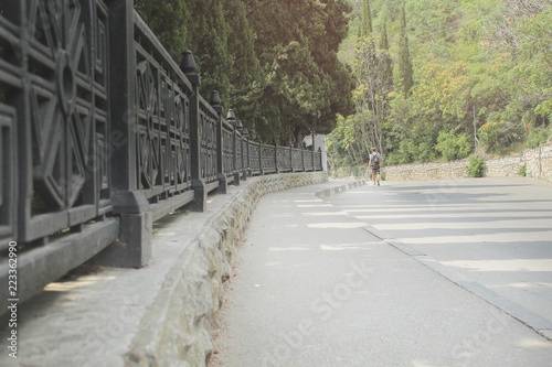 conceptmetal fence along the road in the Park. the man goes into the distance. leaving summer © Олеся Дюканова