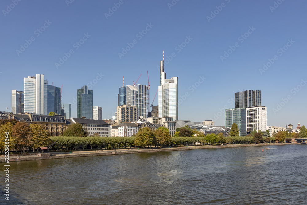 Naklejka premium skyline of Frankfurt in early morning with illuminated skyscraper with river view