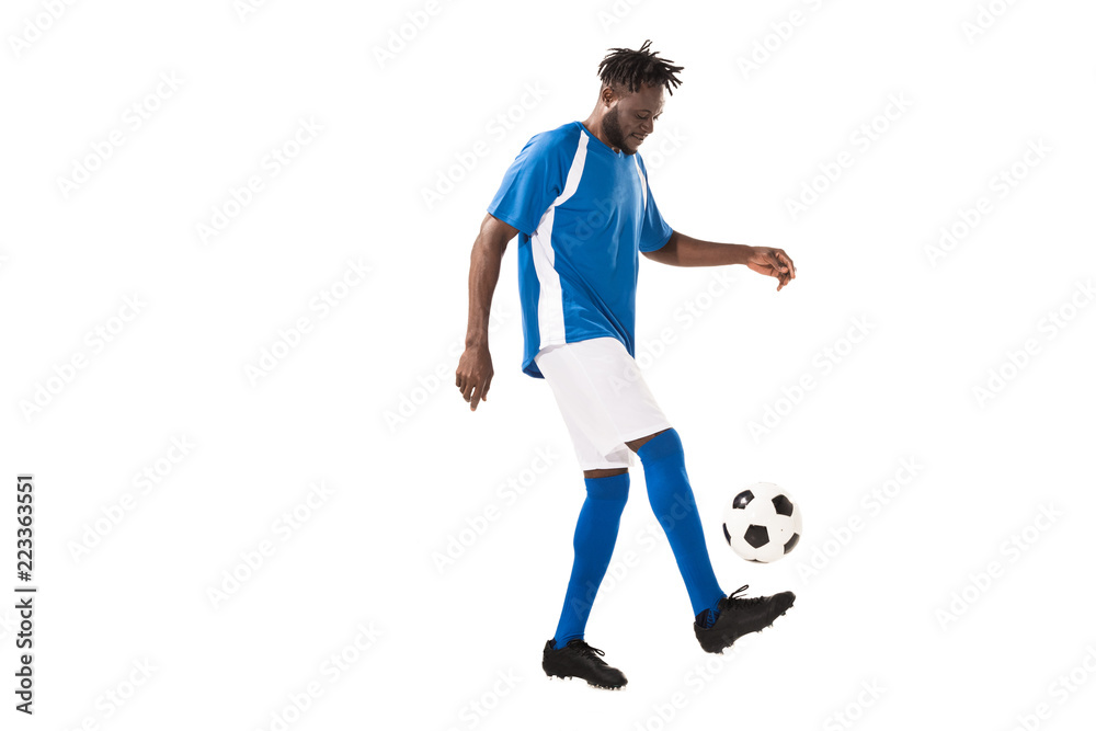 side view of athletic african american sportsman playing with soccer ball isolated on white