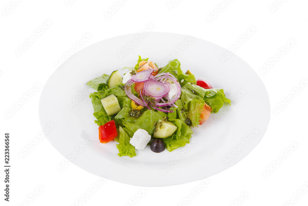 Greek salad with feta, olives, lettuce, red onion, cucumber, tomato, bell pepper, pesto on plate, white isolated background Side view. For the menu, restaurant bar cafe