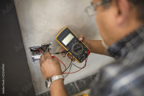 Man checking wall socket with electric current