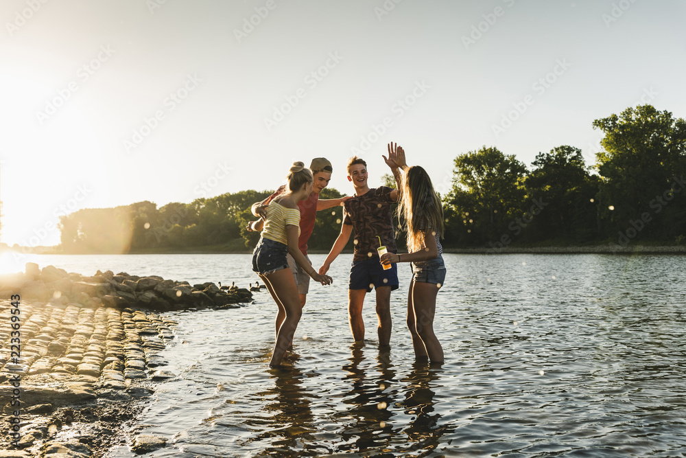 Group of happy friends in a river at sunset Group of happy friends in a river at sunset