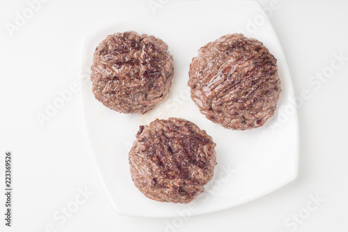 Homemade cutlets on a white plate and white background.