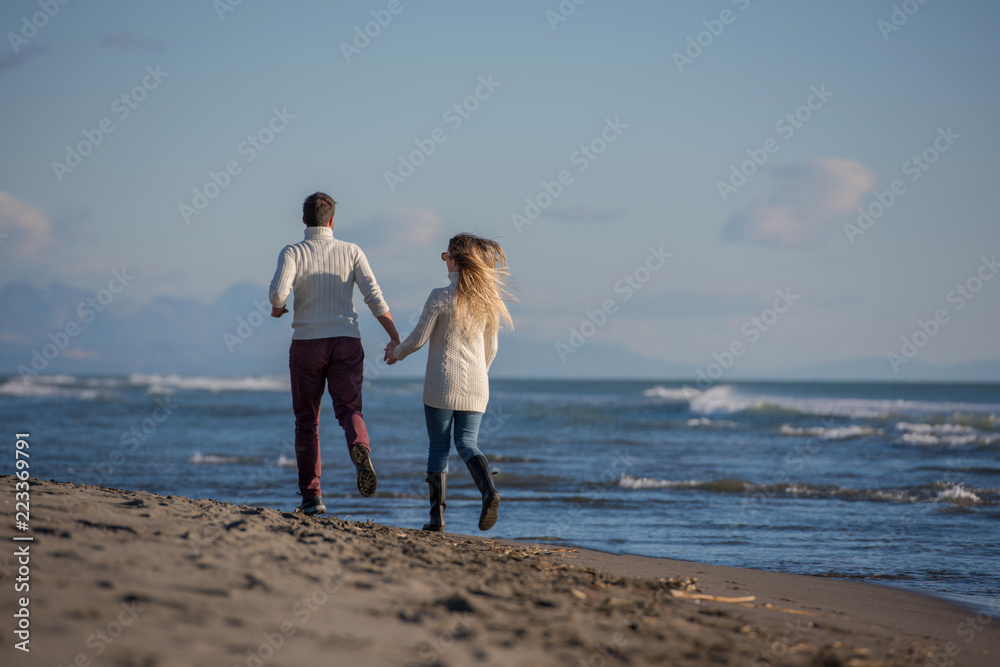 Loving young couple on a beach at autumn sunny day