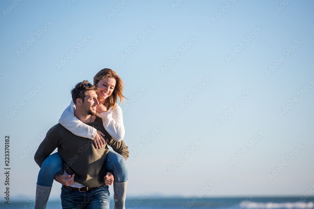 couple having fun at beach during autumn couple having fun at beach during autumn