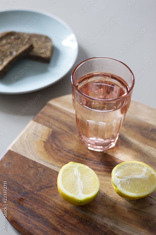glass of water and lemon on wooden table glass of water and lemon on wooden table