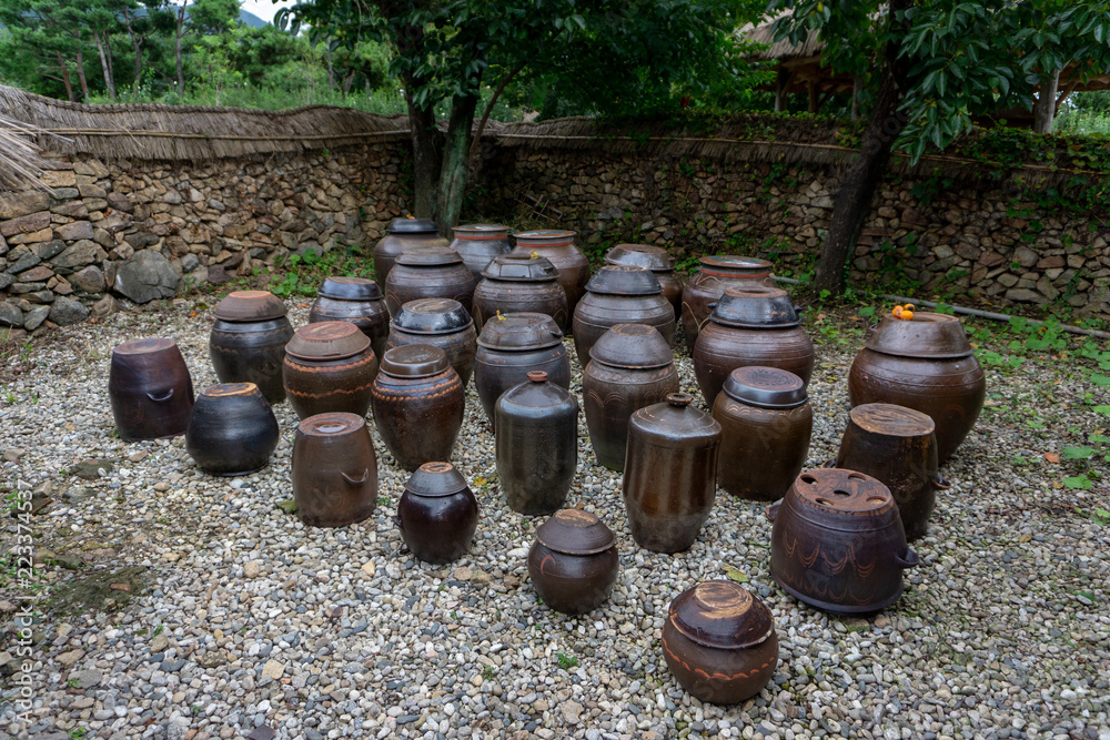 Vases of kimchi were lefted outside the house. Kimchi is a traditional and national food of Korean made with several vegetable mixed with chillies and preserved in the earthenware vesicle, pot or jar. Vases of kimchi were lefted outside the house. Kimchi is a traditional and national food of Korean made with several vegetable mixed with chillies and preserved in the earthenware vesicle, pot or jar.