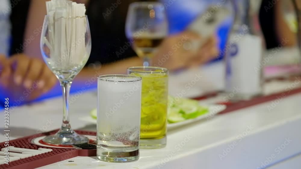Bartender pours sparkling water in a glass with ice and two men take away drinks. HD video Bartender pours sparkling water in a glass with ice and two men take away drinks. HD video