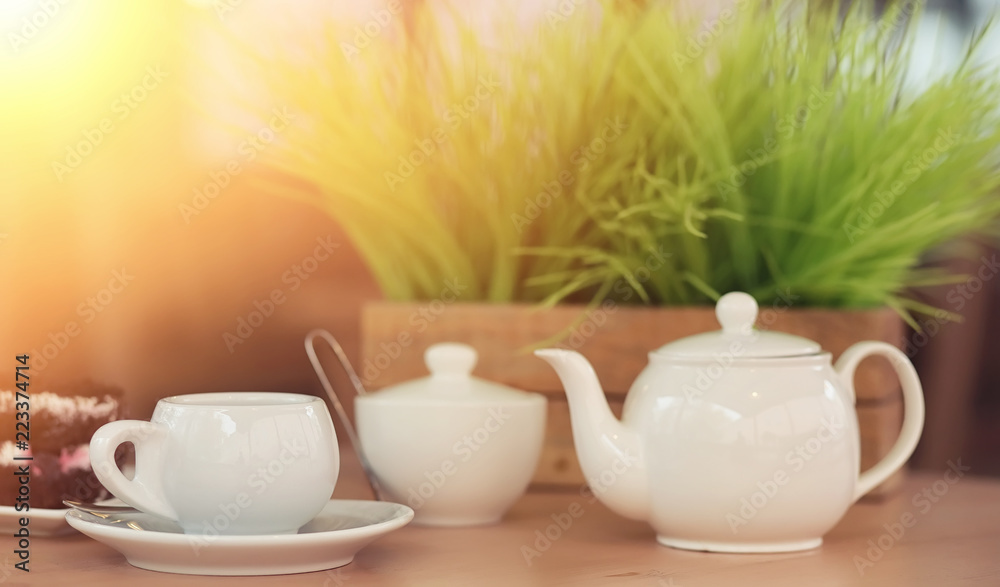 Kettle with a drink and dessert in a street cafe. Tea in the ket Kettle with a drink and dessert in a street cafe. Tea in the ket