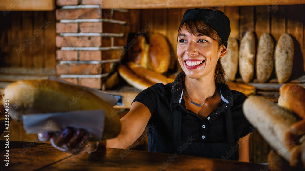 Smiling Female Bakery Assistant Working At Bakery Shop Smiling Female Bakery Assistant Working At Bakery Shop