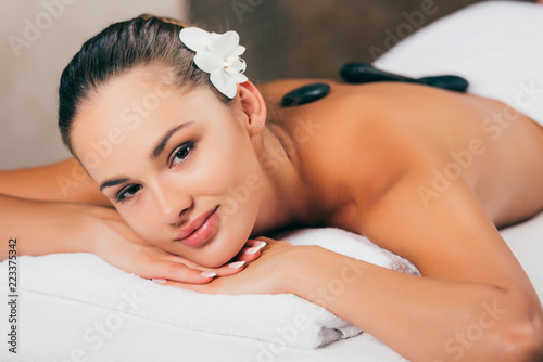 smiling woman having stone therapy at spa salon
