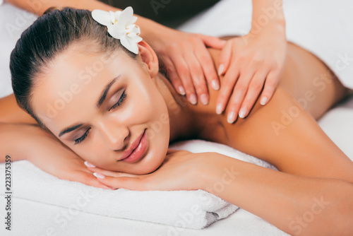 relaxing woman having massage therapy at spa salon
