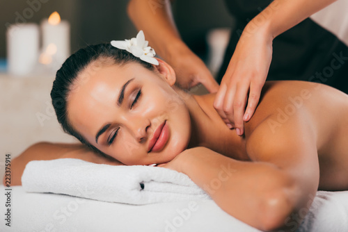 relaxing woman having massage at spa center