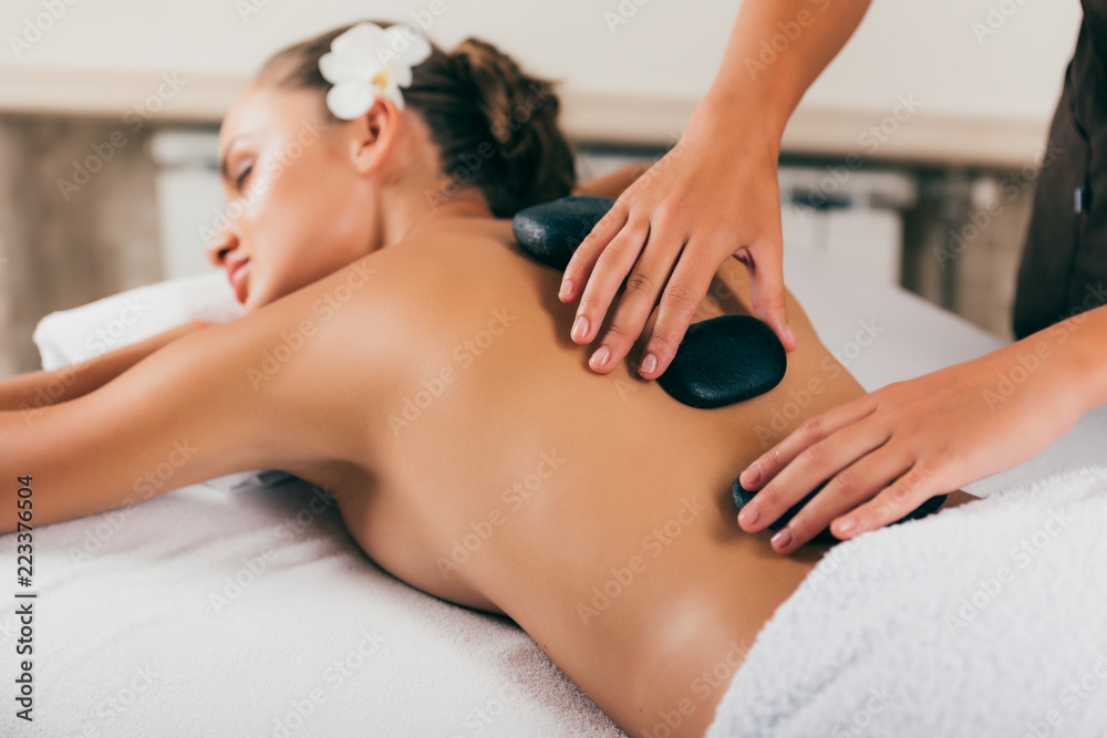 Beautiful woman having stone therapy at spa salon Beautiful woman having stone therapy at spa salon