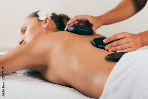 relaxing woman having stone therapy at spa salon