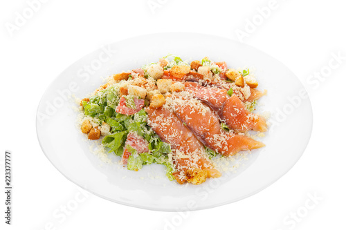 Caesar salad with fish lobes, salmon, trout, biscuits, tomato, lettuce, cheese on plate, white isolated background Side view. For the menu, restaurant bar cafe